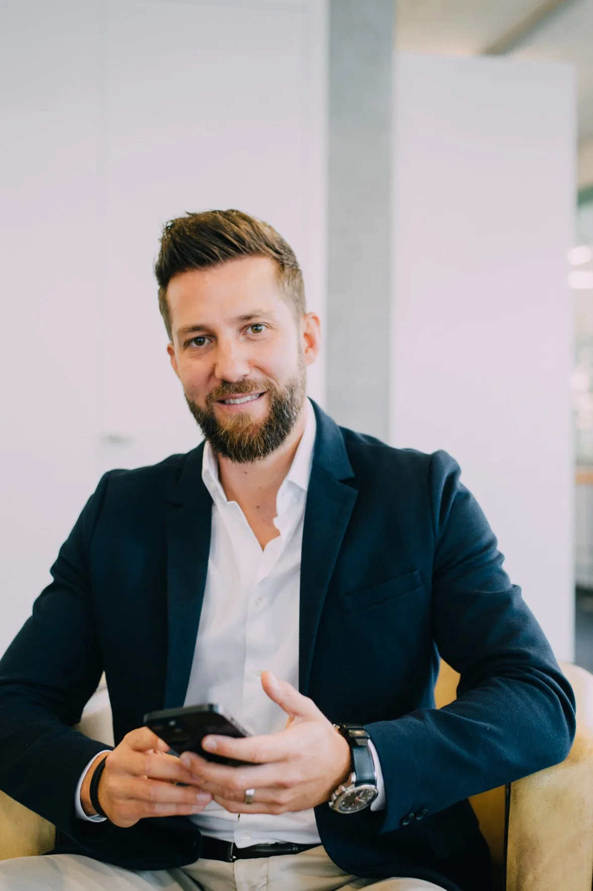 Thomas Ogi übernimmt bei Pidas die Rolle des Chief Commercial Officers. Porträt eines bärtigen Mannes mit Mobiltelefon in der Hand.